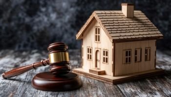 A wooden gavel and model house symbolize legal decisions in real estate matters